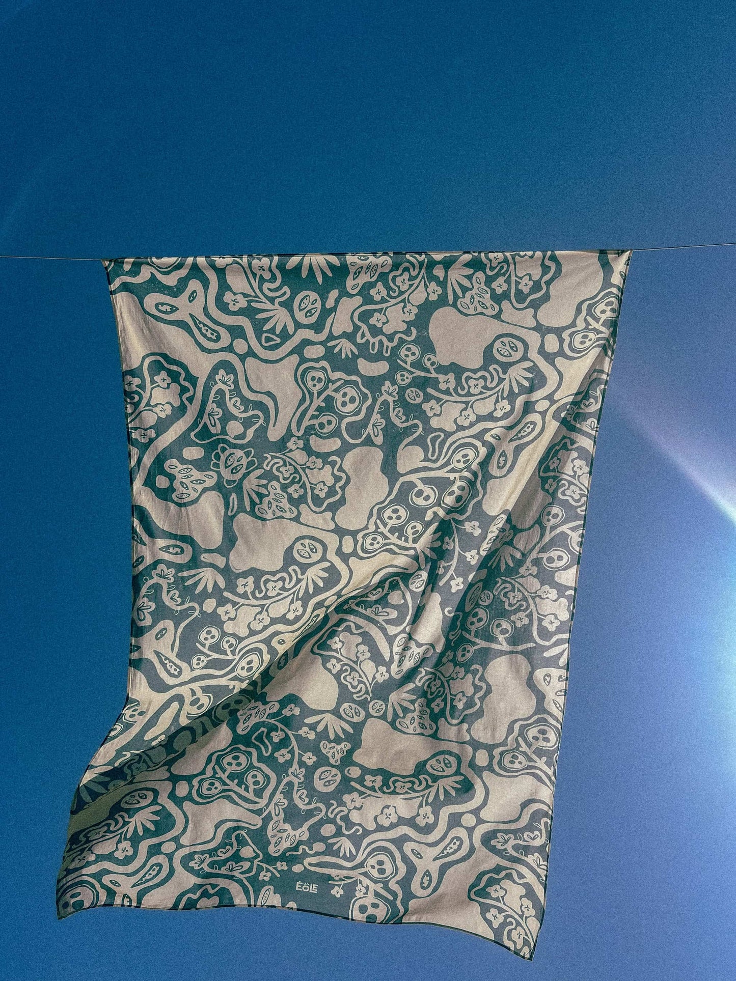 Paréo EOLE en coton bio flottant dans le vent - Motif bleu aux formes organiques sur fond beige - Création artistique éthique