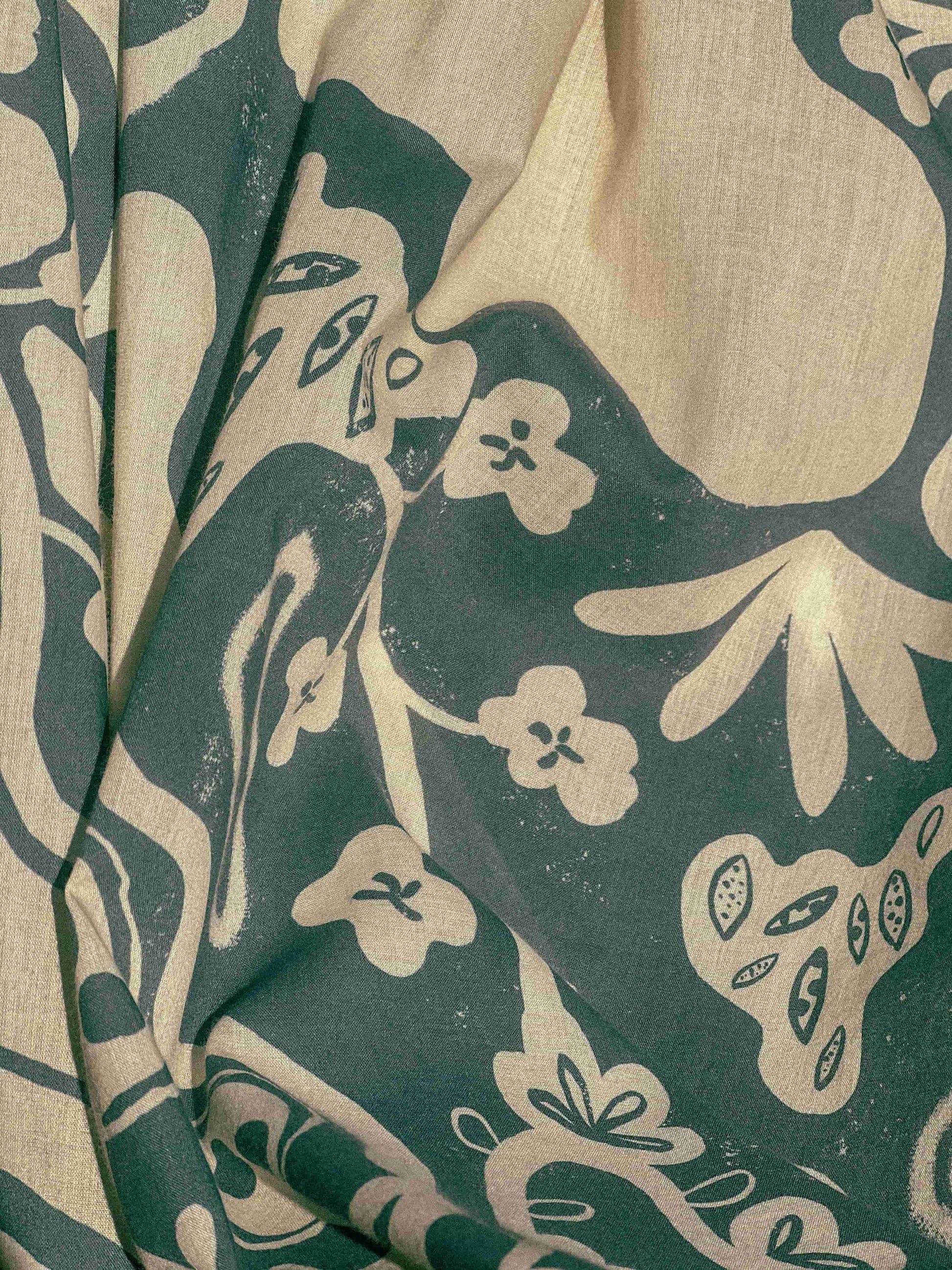 Zoom sur le tissu du paréo EOLE - Détails du motif bleu sur fond beige - Impression artisanale sur coton bio